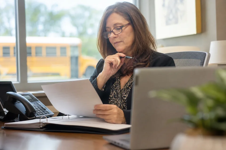 School district HR director reviewing an interview software quote in a district office